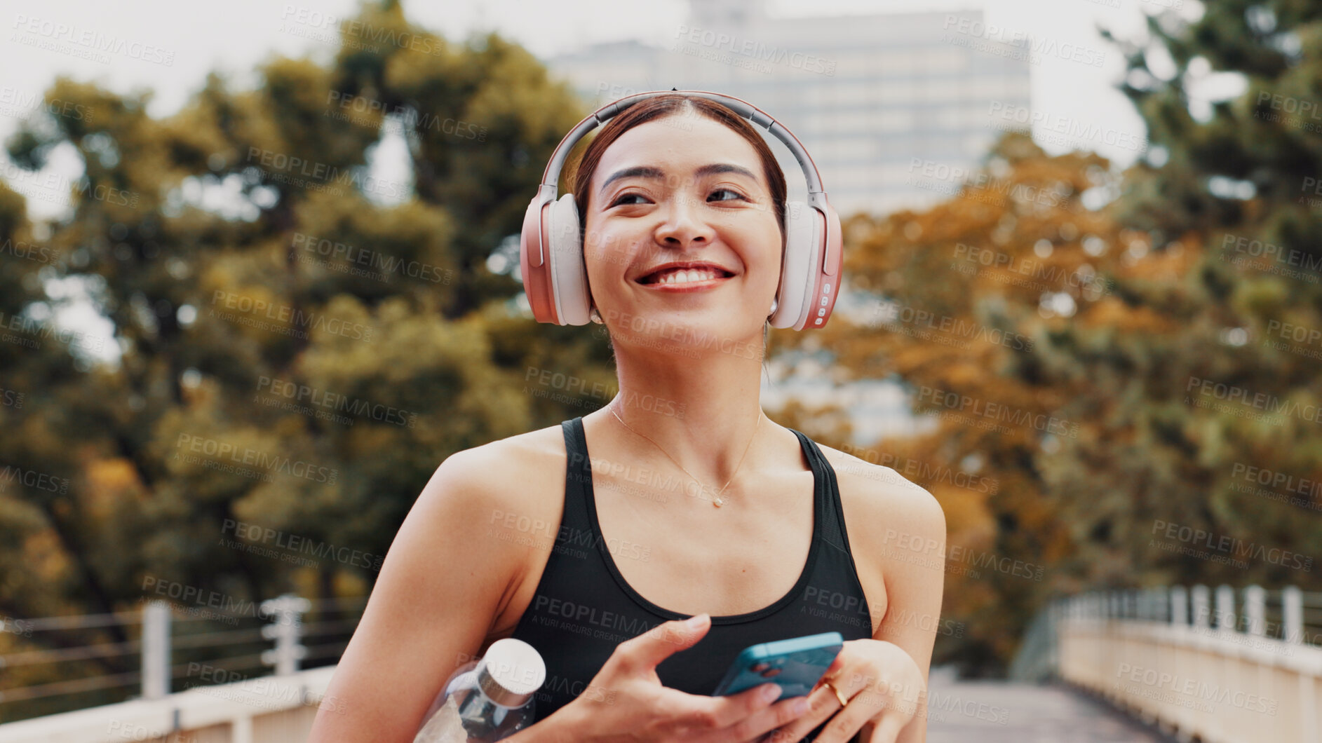 Buy stock photo Thinking, woman and headphones with phone in city, listening to music and fitness podcast. Female athlete, mobile and streaming radio with exercise routine, training website and break on Japan bridge