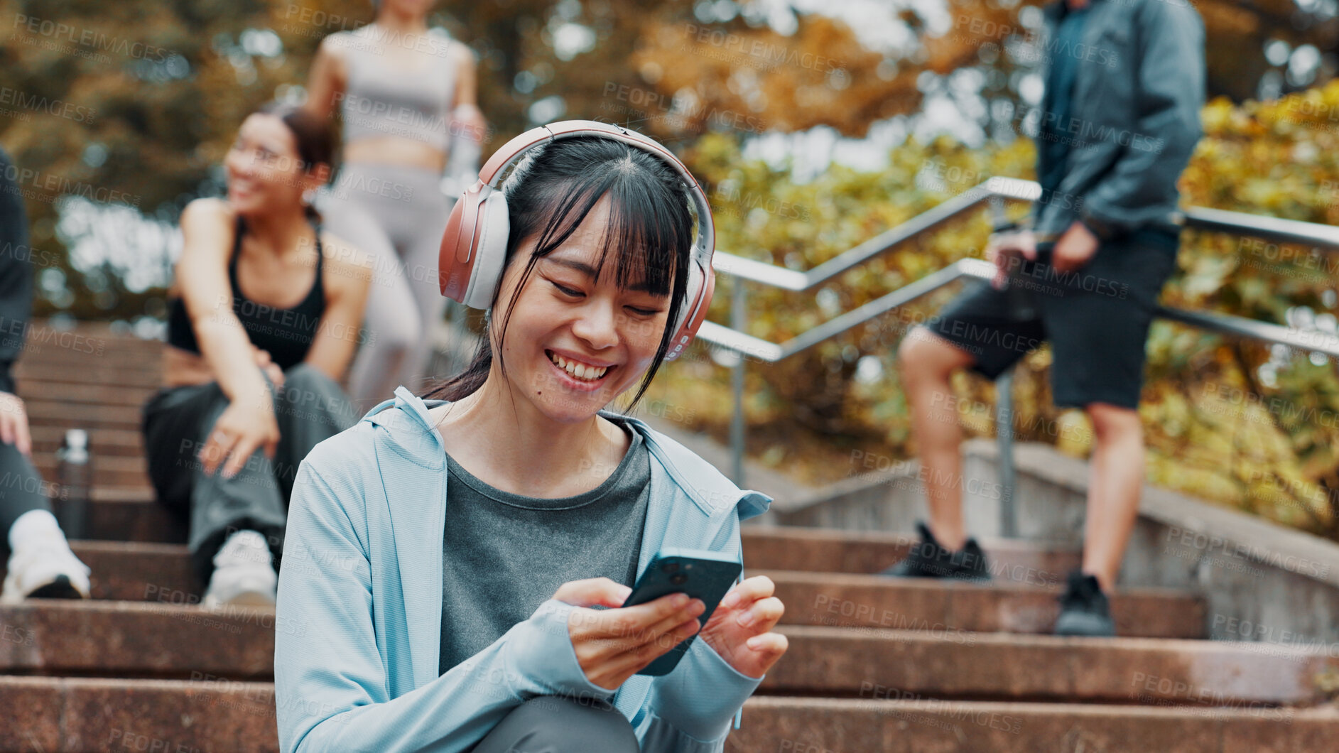 Buy stock photo Woman, fitness break and scroll with phone on park stairs with headphones for online exercise program. Sports, cellphone and Japanese athlete with website for workout, routine and outdoor in nature