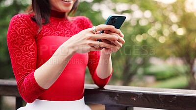 Buy stock photo Hands, phone and texting at park, outdoor and contact for notification, chat and mobile app on patio in summer. Person, smartphone and reading in garden by fence, scroll and social network in Japan