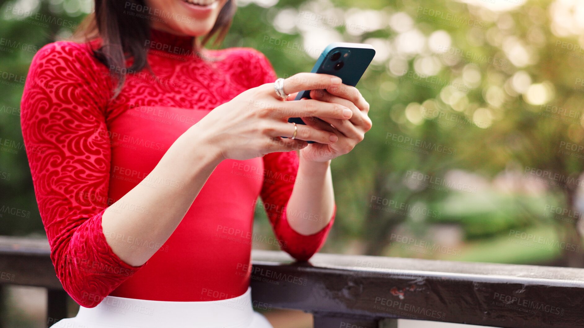 Buy stock photo Hands, phone and texting at park, outdoor and contact for notification, chat and mobile app on patio in summer. Person, smartphone and reading in garden by fence, scroll and social network in Japan