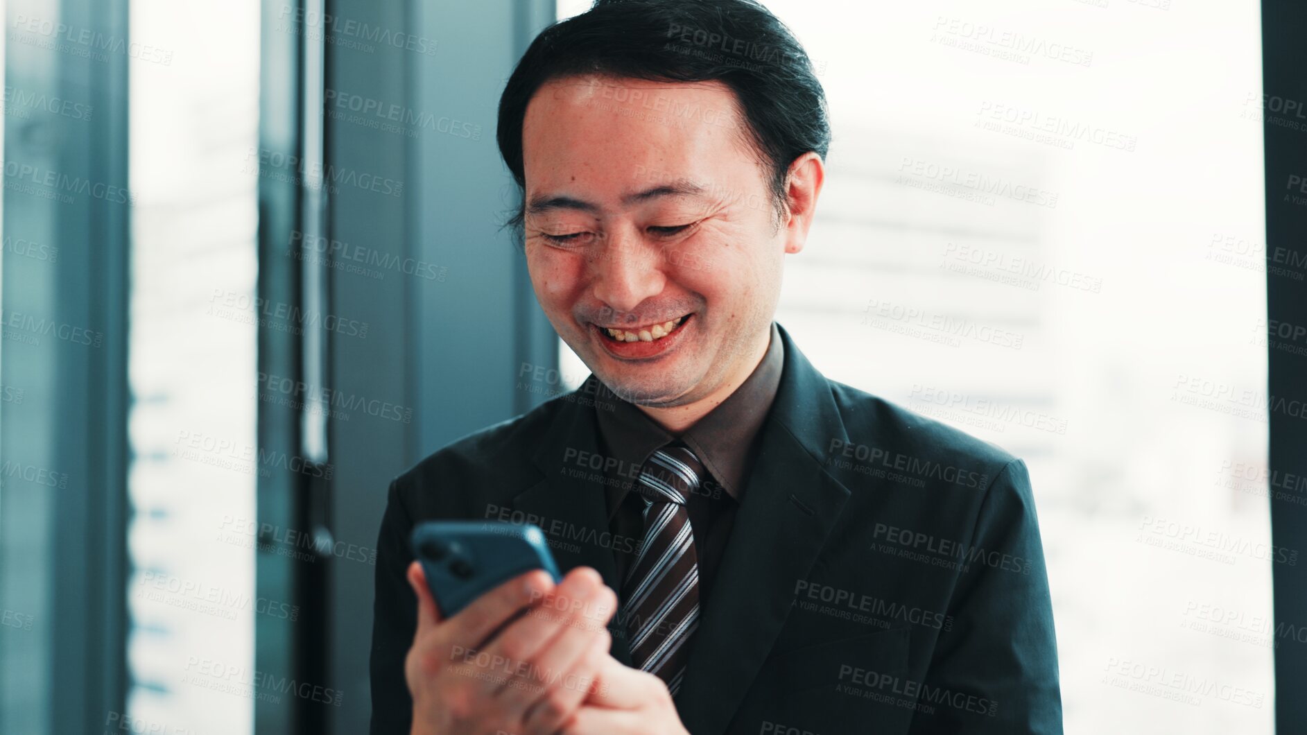 Buy stock photo Man, phone and happy at window for business, research economy and good news in Japanese company. Finance investor, tech and reading in office for report, stock market update or investment opportunity