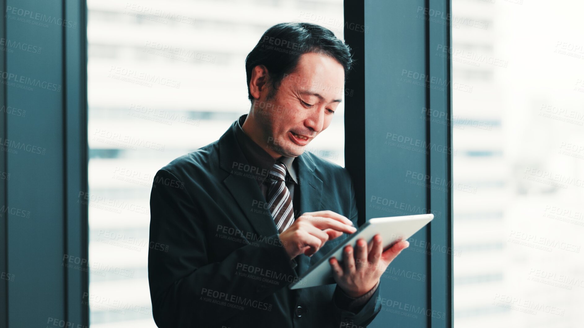 Buy stock photo Man, tablet and happy at window for business, research economy and good news in Japanese company. Finance investor, tech or reading in office for report, stock market update or investment opportunity