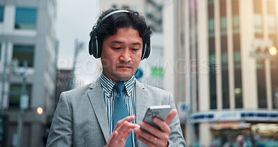 Buy stock photo Business, man and phone with headphones in city for listening to music, travel guide and search playlist. Male person, mobile and podcast with morning commute, streaming radio and directions in Japan