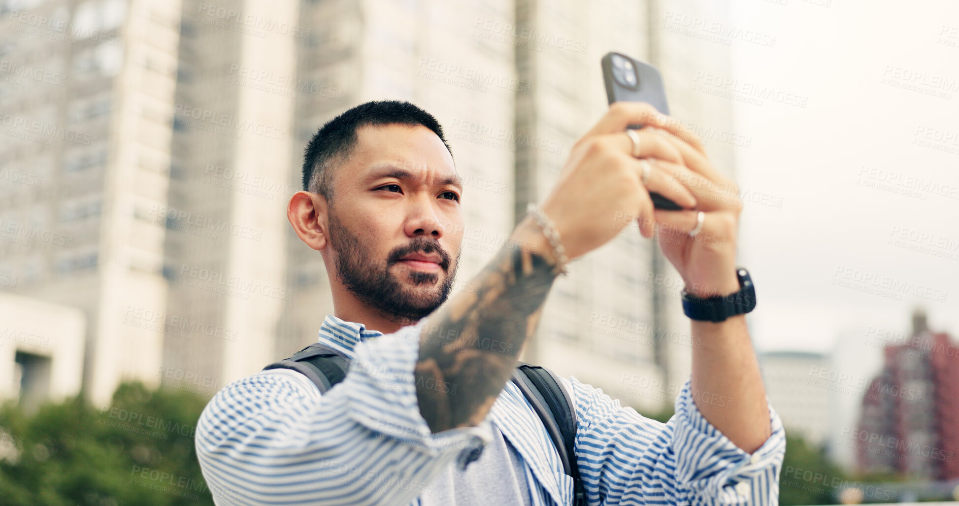 Buy stock photo Man, phone and travel in city with photography for memory, location and mobile app on commute in street. Person, smartphone and outdoor for profile picture, post and social media on sidewalk in Japan