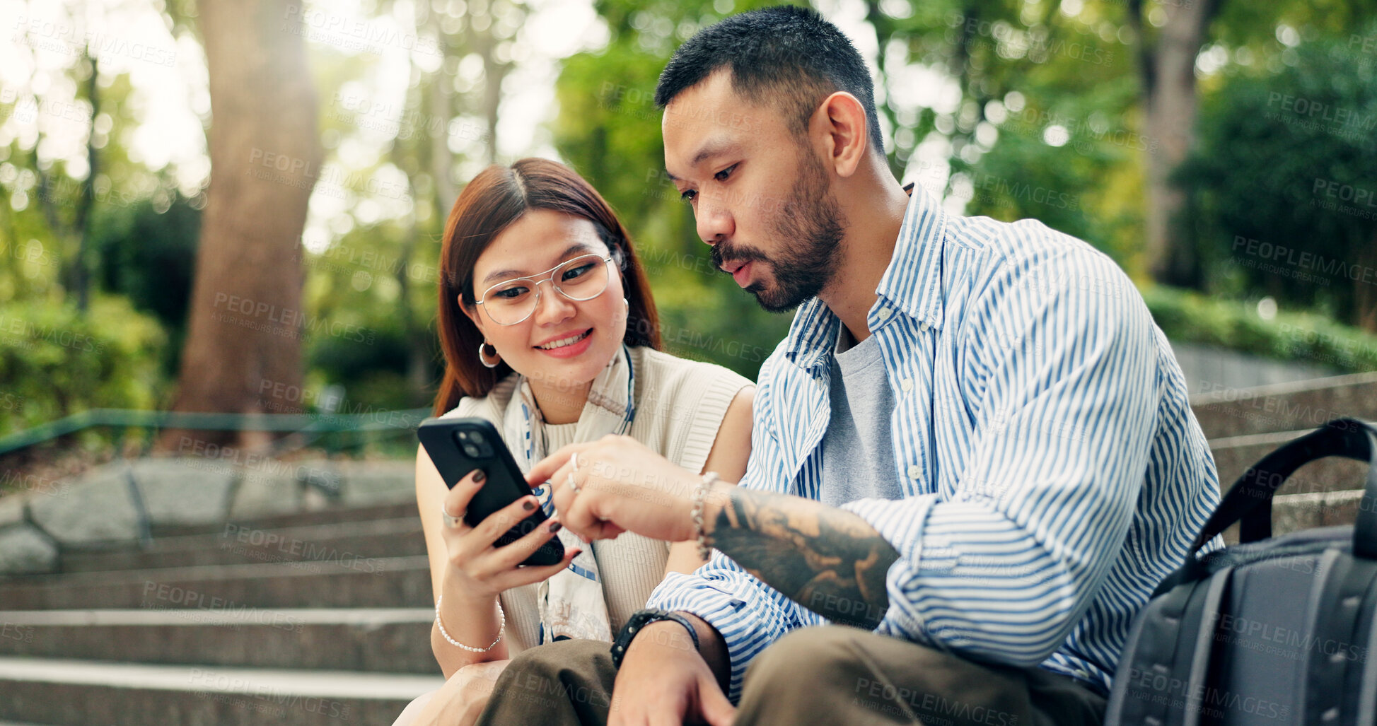 Buy stock photo Couple, phone and happy on travel at park on stairs, click and decision for hotel booking with mobile app. People, man and woman with smartphone, reading and notification on social network in Japan