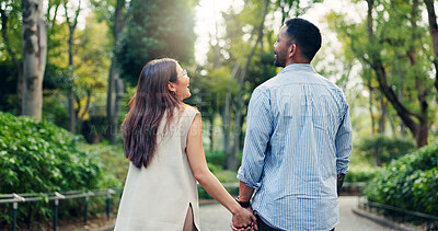 Buy stock photo Couple, holding hands and talking or walking in park, back and funny joke on honeymoon vacation. People, security and outdoor support on holiday in Japan, travel together and explore relationship