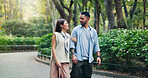 Couple, conversation and walking in calm park of Japan, love and bonding on honeymoon vacation. People, security and outdoor support on holiday in nature, travel together and explore relationship