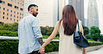 Couple, holding hands and walking in urban town of Japan, love and bonding on honeymoon vacation. People, security and outdoor support on holiday in city, travel together and explore relationship