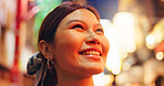 Asian, happy woman and face with night in city for travel, sightseeing or tourism on bokeh background. Japan, tourist or female person with smile for destination, trip or holiday vacation in Tokyo