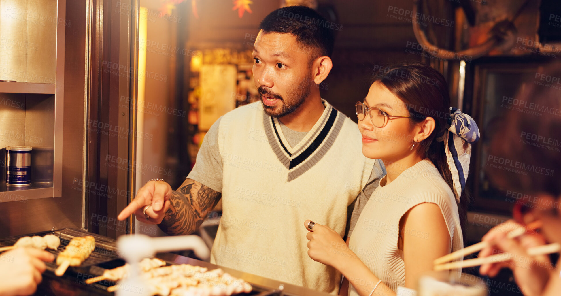 Buy stock photo Street food, night and shopping of Japanese couple at market for culture festive, nutrition or health. Travel, hunger and cuisine with man and woman at Japan city vendor for date and holiday