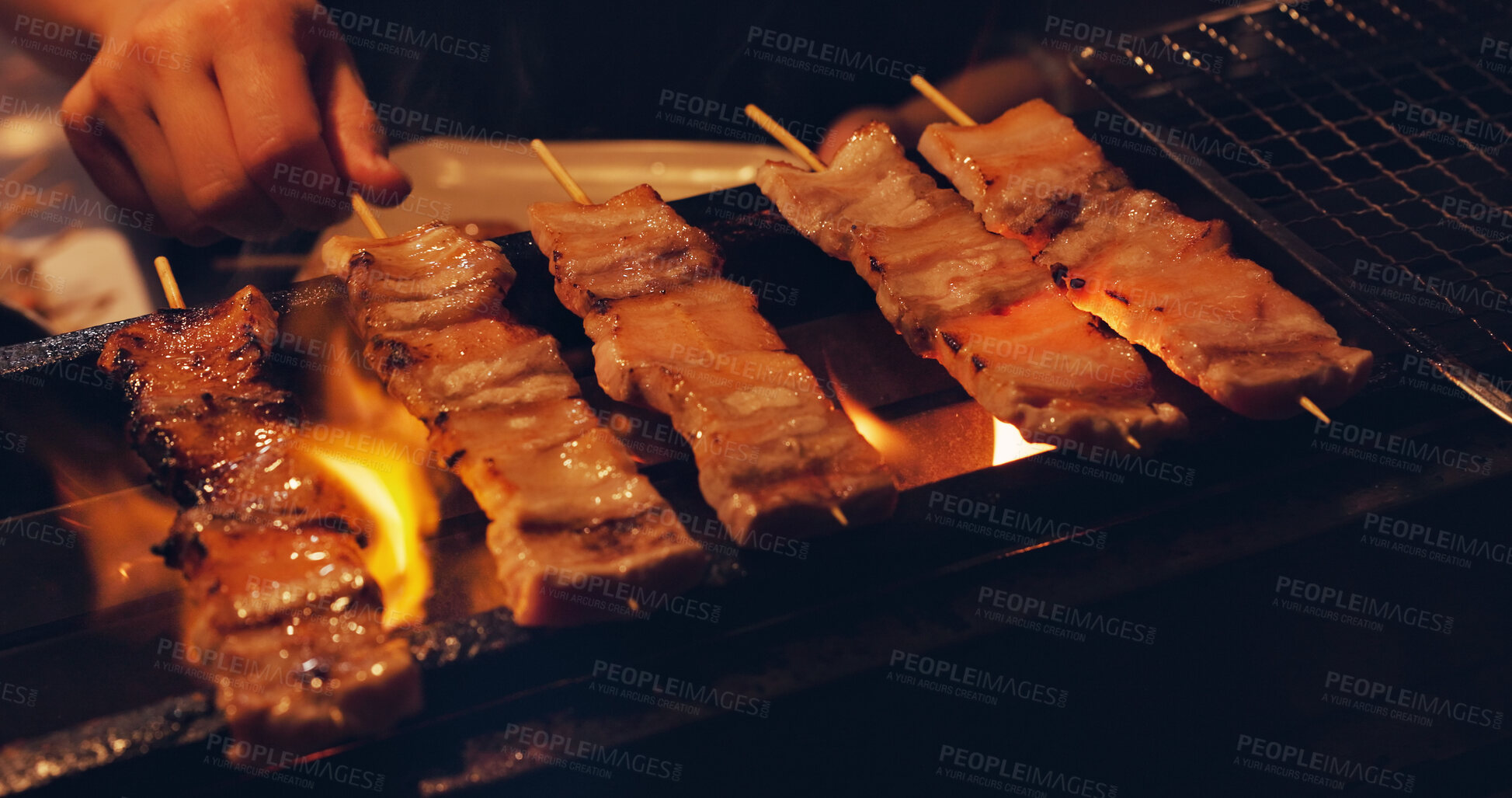 Buy stock photo Pork skewer, hands and Japanese street food on grill, outdoor barbecue or meat kebab on fire for dinner. Asian cuisine, festival culture and person cooking yakiton on charcoal flames at local market