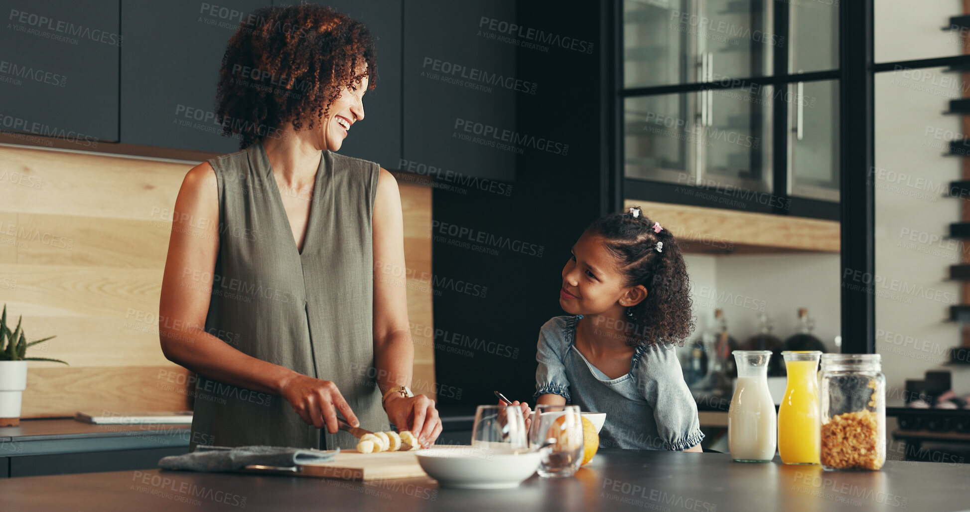 Buy stock photo Laugh, child and happy mother cooking breakfast, funny joke or chop banana and healthy fruit in family home. Mom, kid and prepare morning food in kitchen, help or parent teaching girl organic recipe