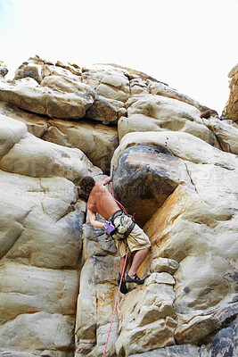 Buy stock photo Man, mountain and rock climbing or chalk for grip as outdoor performance, adventure or gear. Male person, hanging and rope on cliff or fearless danger on boulder stone, training for exercise discover