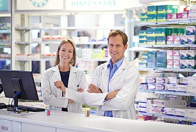 Buy stock photo Portrait of two pharmacists standing at the prescription counter