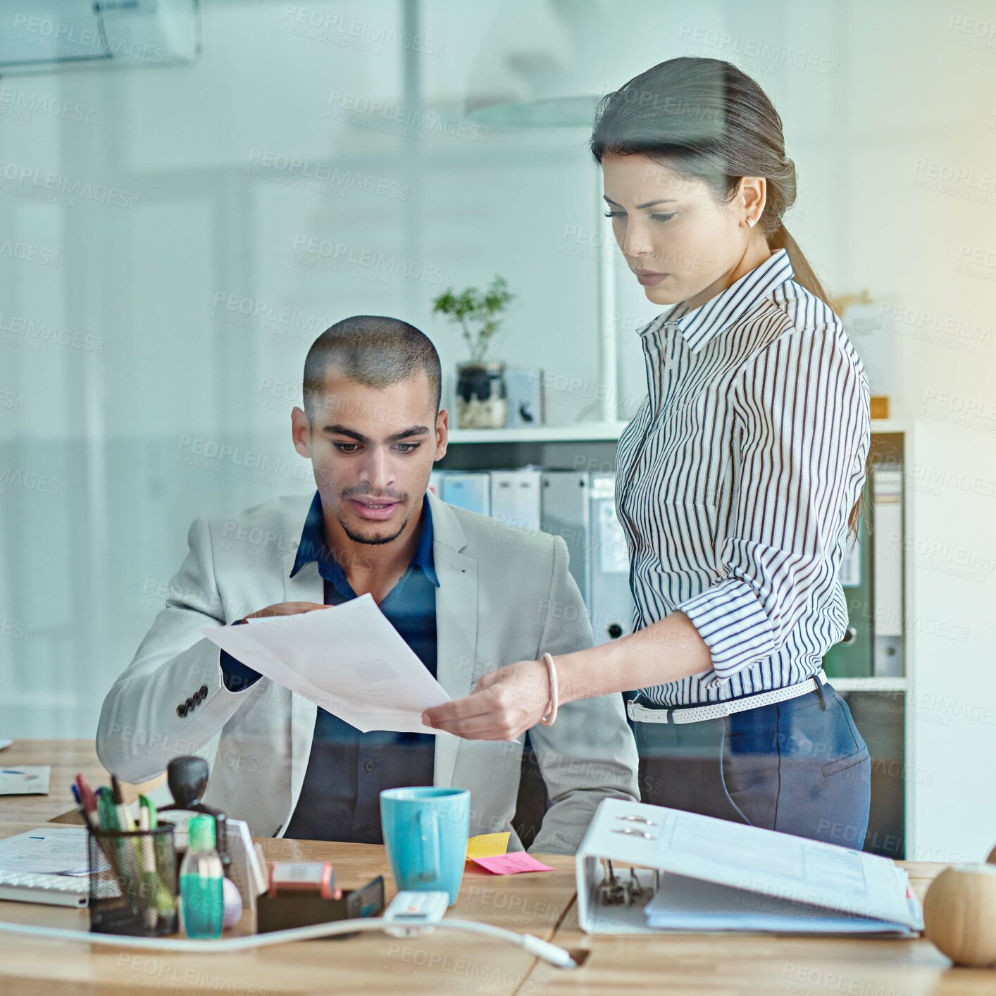 Buy stock photo Cropped shot of two businesspeople looking through some paperwork in an office