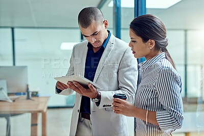 Buy stock photo Cropped shot of two businesspeople working together on a digital tablet in an office