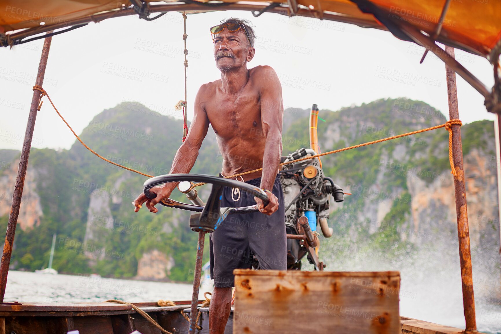 Buy stock photo Shot of a Thai man operating his tourist boat