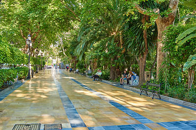 Buy stock photo Park, travel and walkway with tourist people at Parque de la Alameda in Marbella, Spain. Nature, trees and spring with brick lane road outdoor in conservation location for sightseeing or tourism