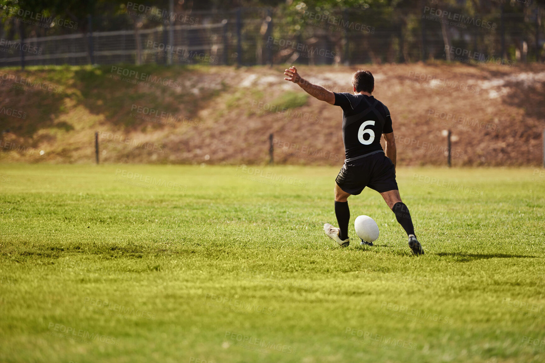 Buy stock photo Ball, kicking and rugby with man on field from back for start of competition, game or tournament. Exercise, fitness and kickoff with sports player outdoor at venue for scoring or shooting at goal