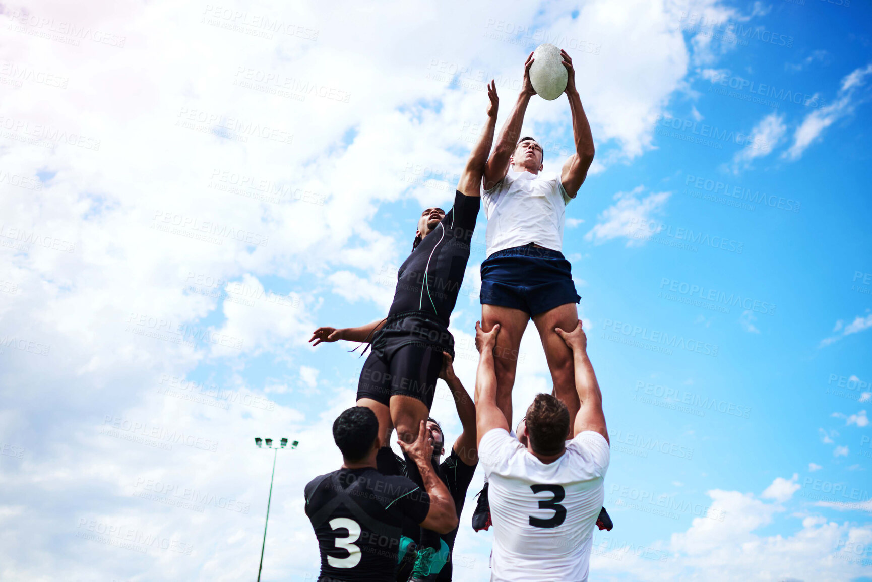 Buy stock photo Men, blue sky and rugby ball for jump, outdoor and challenge in exercise, wellness and fitness. Male people, athlete and recreation facility as team for match, sports and training in stadium or arena