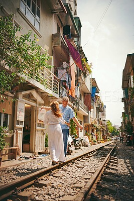 Buy stock photo Travel, couple and romantic holiday on railway track for honeymoon adventure, balance or sightseeing Vietnam. Tourist, mature man and explore destination for relationship vacation, bonding and love