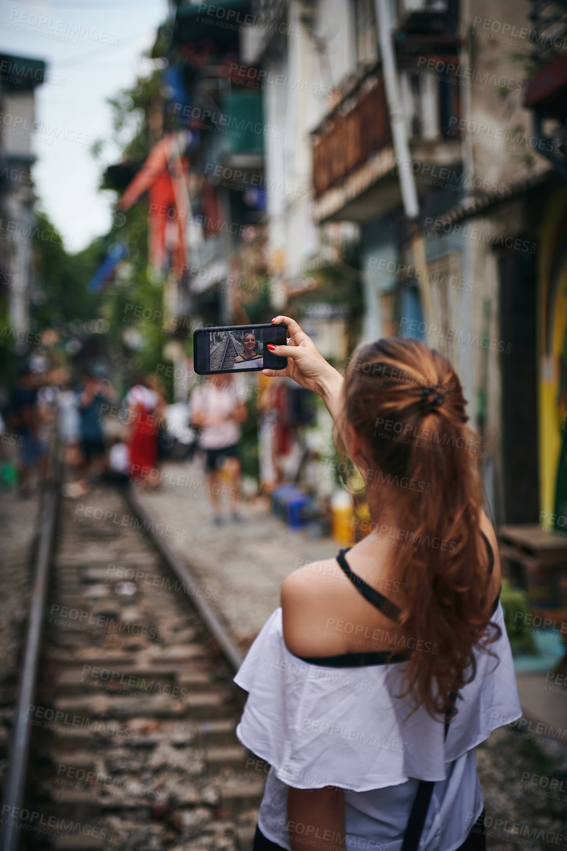 Buy stock photo Woman, selfie and phone screen for travel on train track, adventure or post for tourism in city. Girl, person and back on railway for journey, photography or live stream on social media in Thailand