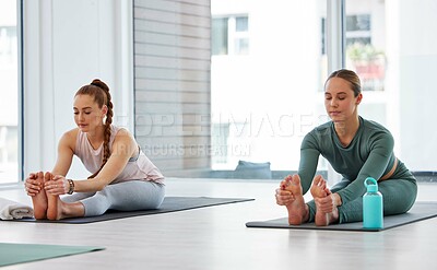 Buy stock photo Yoga, class and women stretching legs in studio for holistic healing, mindfulness and healthy body. Chakra, workout and people with exercise on mat for self care, awareness and flexibility on weekend