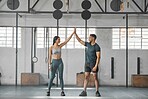 Fit, active and healthy sports athletes training together in gym workout room, living a strong wellness lifestyle. Male and female fitness instructors celebrate and smiles in physical exercise class