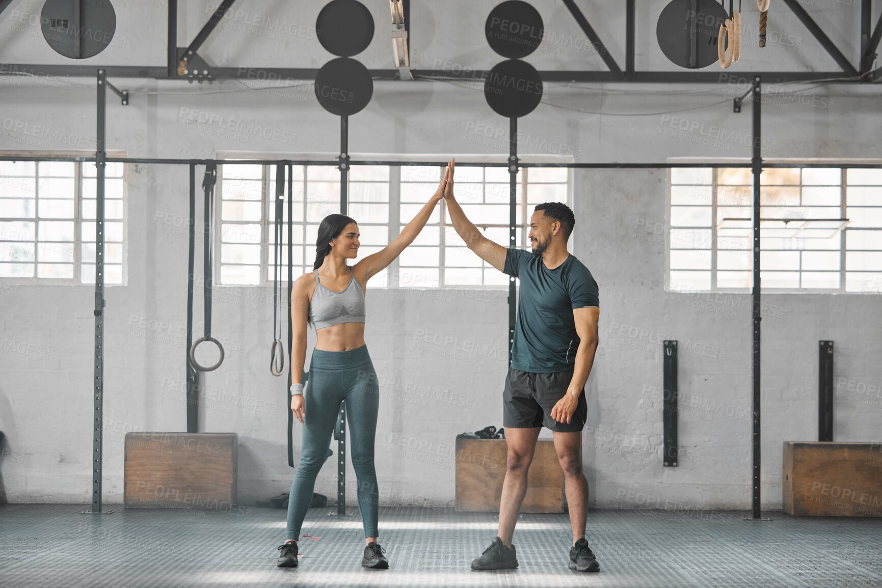 Buy stock photo Fit, active and healthy sports athletes training together in gym workout room, living a strong wellness lifestyle. Male and female fitness instructors high five and smiles in physical exercise class