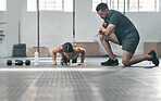 Active, fit and athletic woman training with her personal trainer at the gym. A female athlete doing pushups with her coach for her morning workout routine at a fitness and exercise facility