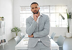Young focused mixed race businessman standing in an office alone. One serious confident hispanic male boss at work