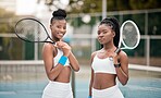 Two professional tennis players ready for a match. Young women holding their rackets on the tennis court. Two friends ready for tennis practice. Sporty, fit athletes ready for a game of tennis