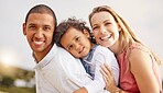 Portrait of a happy mixed race family spending time together on the beach. Adorable little girl enjoying vacation with her mother and father