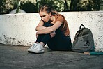 University, sad and woman student sitting outside in depression for fail on education exam. College, depressed and upset female sit on floor outdoors upset about educational learning book