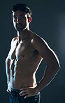 Fitness, sports and portrait of swimmer with tattoo isolated in studio for wellness, exercise and training. Workout, swimming athlete and man on dark background with muscles, strong body and goggles