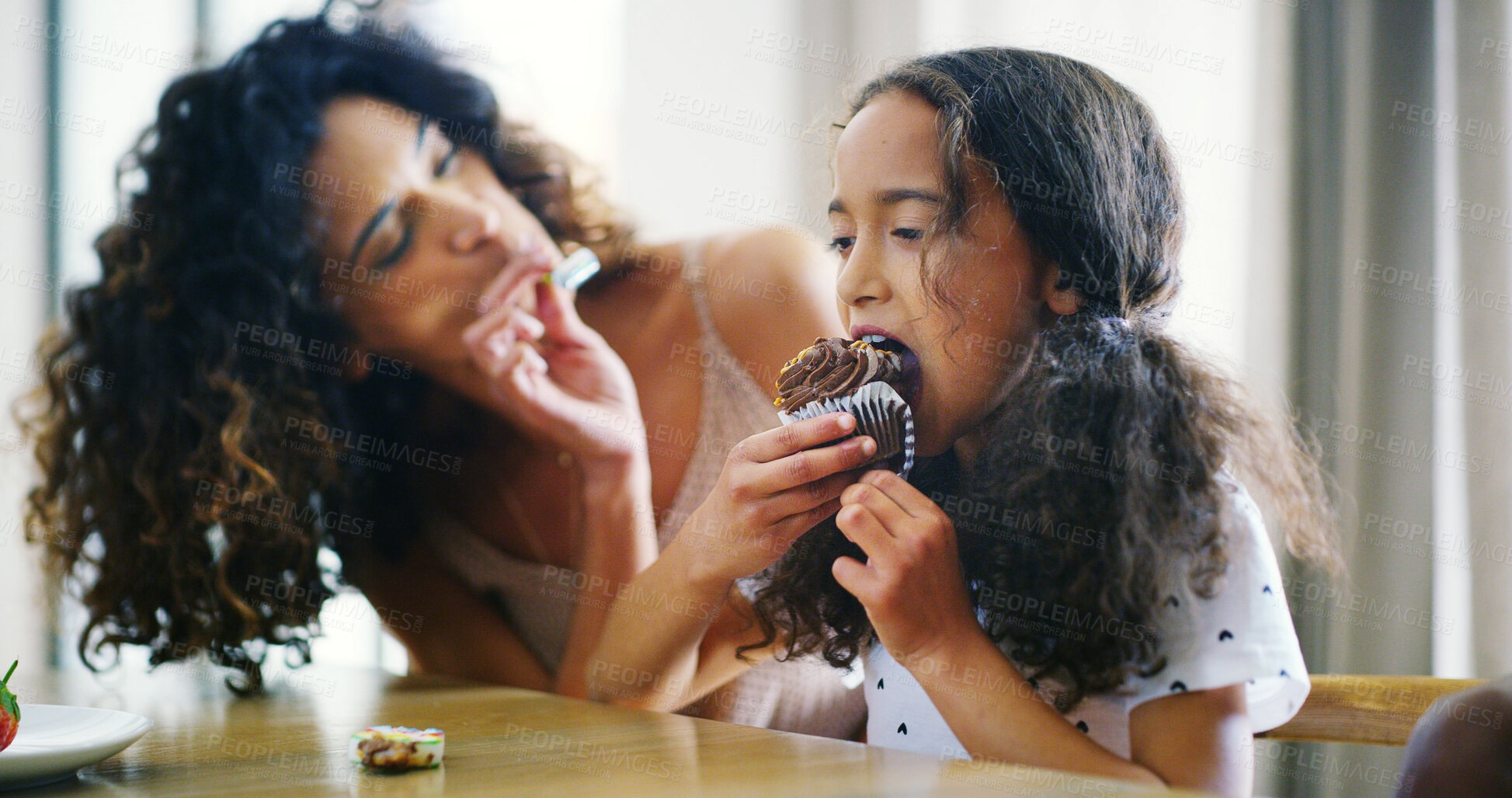 Buy stock photo Mother, girl and happy with feeding cupcake at home for bonding, care and support. People, family and parent with kid for eating dessert or food as meal at apartment for fun and child development