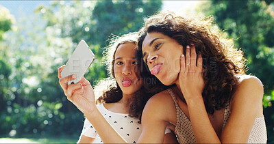 Buy stock photo Selfie, funny face and mother with daughter in park for social media, memory and bonding. Love, support and photography with woman and young girl in nature for picture, family and tongue out together