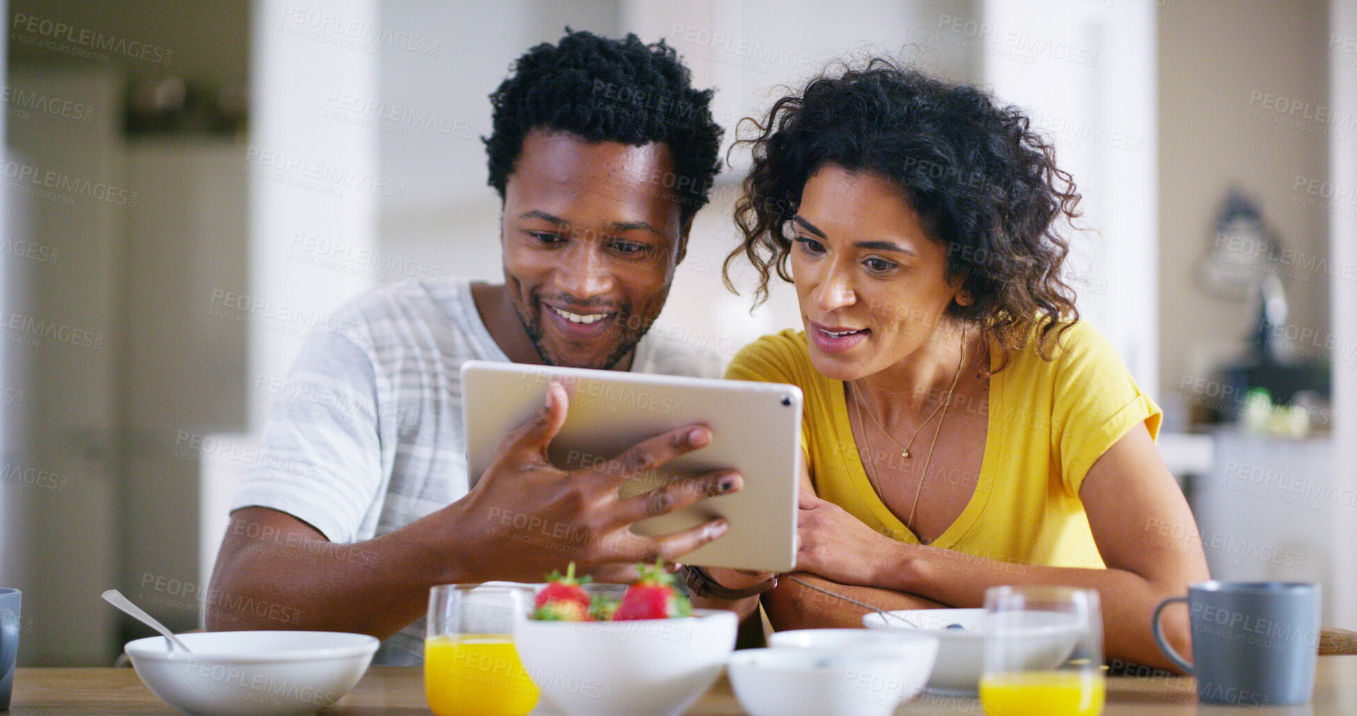 Buy stock photo Happy, interracial couple and morning with tablet for browsing, social media or entertainment at home. Man, woman or lovers with smile, breakfast or technology for online streaming or connectivity