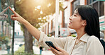 Asian woman, phone or tourist with city map for information, guide or directions in urban town. Japan, female person or tourism with mobile smartphone or self service navigation for point of interest