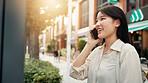 Phone call, networking and woman in city for travel, vacation or weekend trip with direction board. Happy, cellphone and Japanese female person on mobile conversation for communication on holiday.