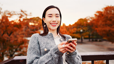 Buy stock photo Portrait, phone and happy woman outdoor for travel, text or message on app in Japan. Face, mobile and Asian person at park for holiday, vacation or post on social media profile on internet at sunset