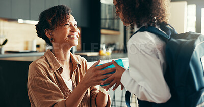 Buy stock photo Mom, girl and smile with lunchbox in home for preparing or ready for elementary education. Apartment, people and parent with kid in uniform for first day at school with food, pride and child growth