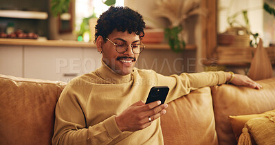 Buy stock photo Smartphone, young man and mobile app in home with smile, texting or communication on couch for relax. Male person, positive and happy on technology in apartment for post, online and website in lounge