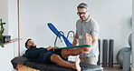 Physiotherapist, people and band for stretching legs at clinic, helping and recovery on table. Men, flexibility exercise and chiropractor for rehabilitation treatment, support and training service