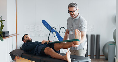 Buy stock photo Physiotherapist, people and band for stretching legs at clinic, helping and recovery on table. Men, flexibility exercise and chiropractor for rehabilitation treatment, support and training service