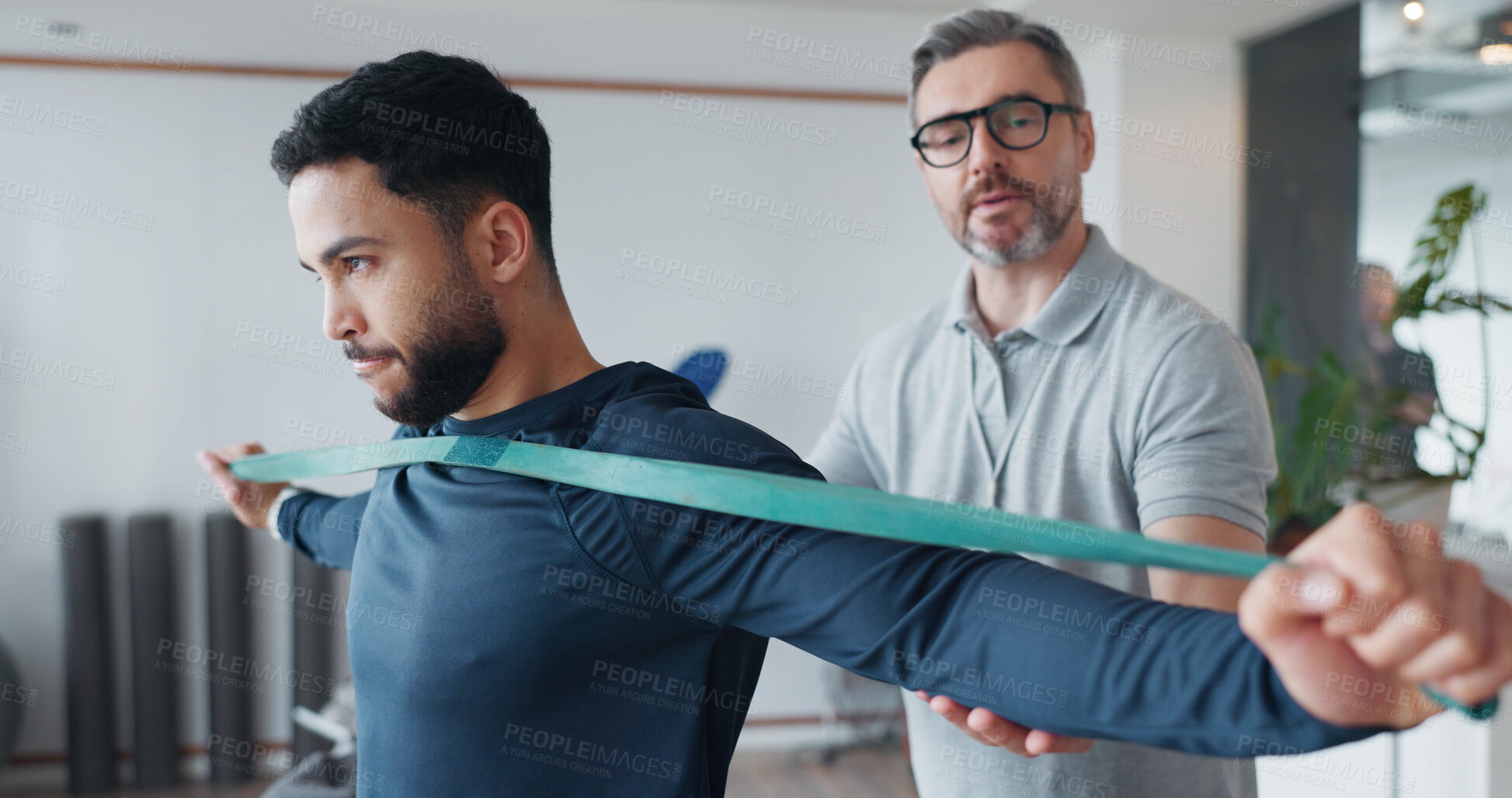 Buy stock photo Physiotherapy, resistance band and consulting with man and athlete in clinic for rehabilitation, healthcare or stretching. Support, medical and muscle with people for healing, advice or recovery