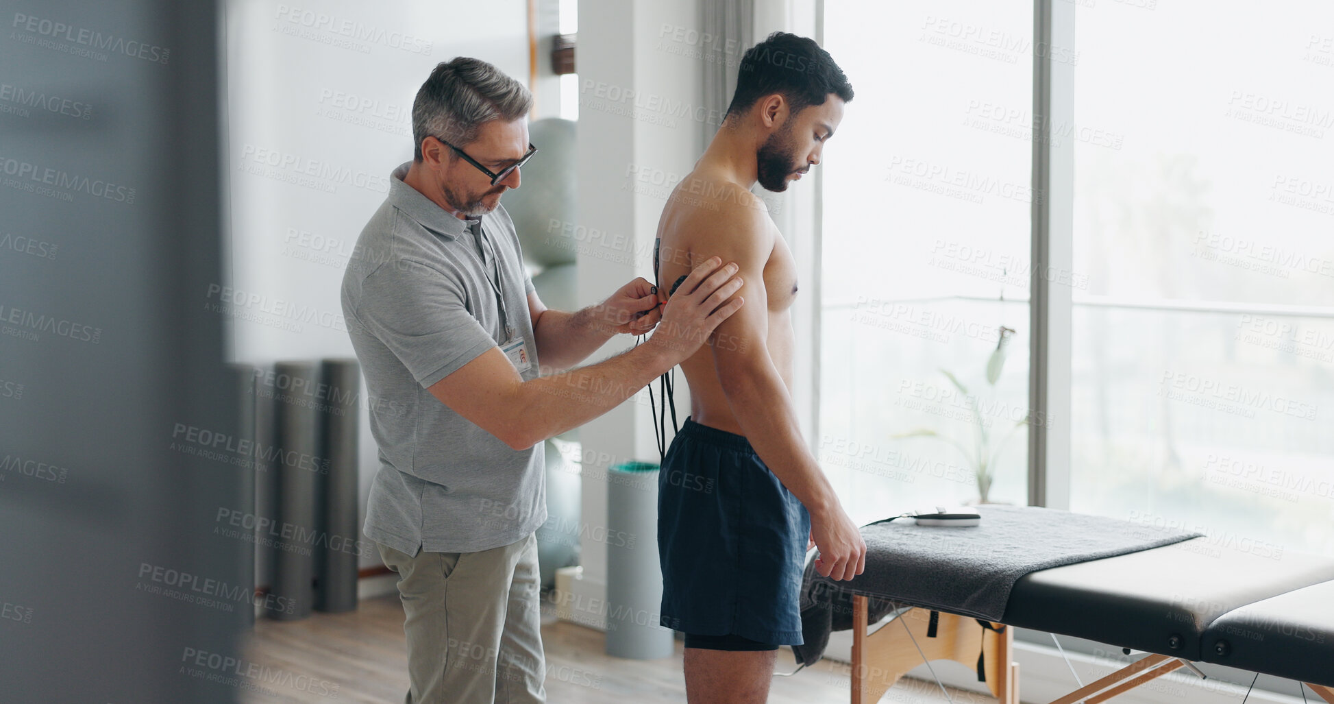 Buy stock photo Electrodes, physiotherapy and consulting with people in clinic for muscle stimulation therapy, results and healthcare. Medical, rehabilitation and back with patient and man for support, help and exam