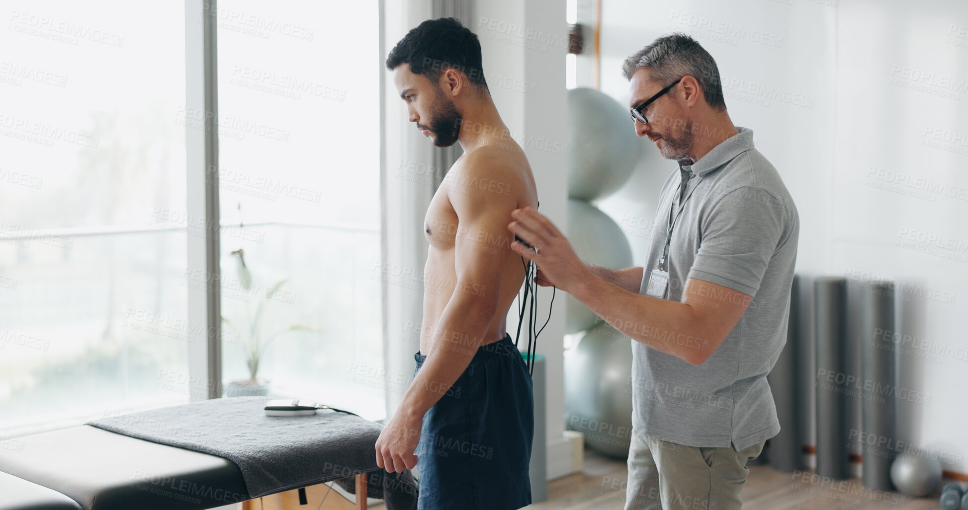 Buy stock photo Physiotherapy, consulting and electrodes with man in clinic for biofeedback, muscle stimulation and track progress. Rehabilitation, healthcare and body with people for chiropractor, help and healing