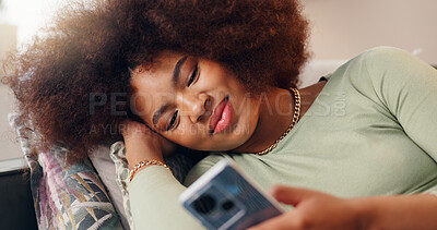 Buy stock photo Smile, mobile and woman in home online, texting and reading social media blog post to relax. Happy, phone and African girl on sofa for communication, streaming show and download chat app on internet