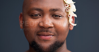 Buy stock photo Portrait, skincare and black man in studio with flowers, confidence and natural self care in lgbt aesthetic. Nature, floral and male person with gay pride, creative dermatology and grey background